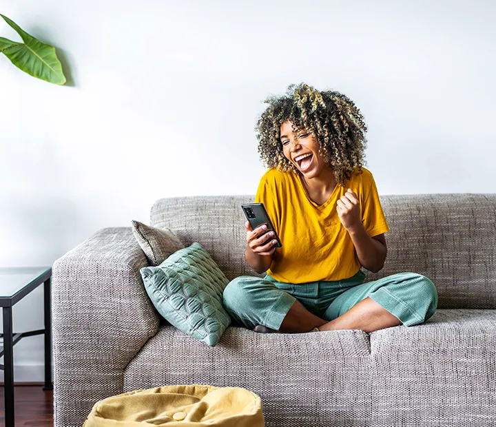 happy young black woman holding smart phone
