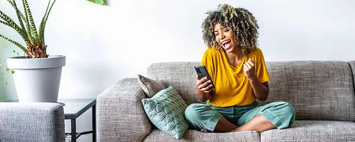 happy young black woman holding smart phone