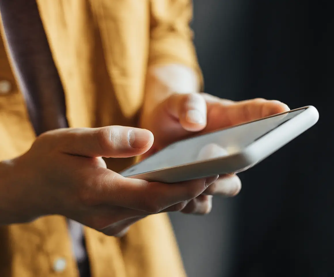 Hands of a man using a smartphone, a close up.