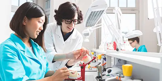 dental student and dental assistant conversing about the denture