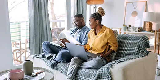 couple sitting on their couch planning their budget