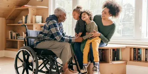man in wheelchair playing with daughter and grand kids 