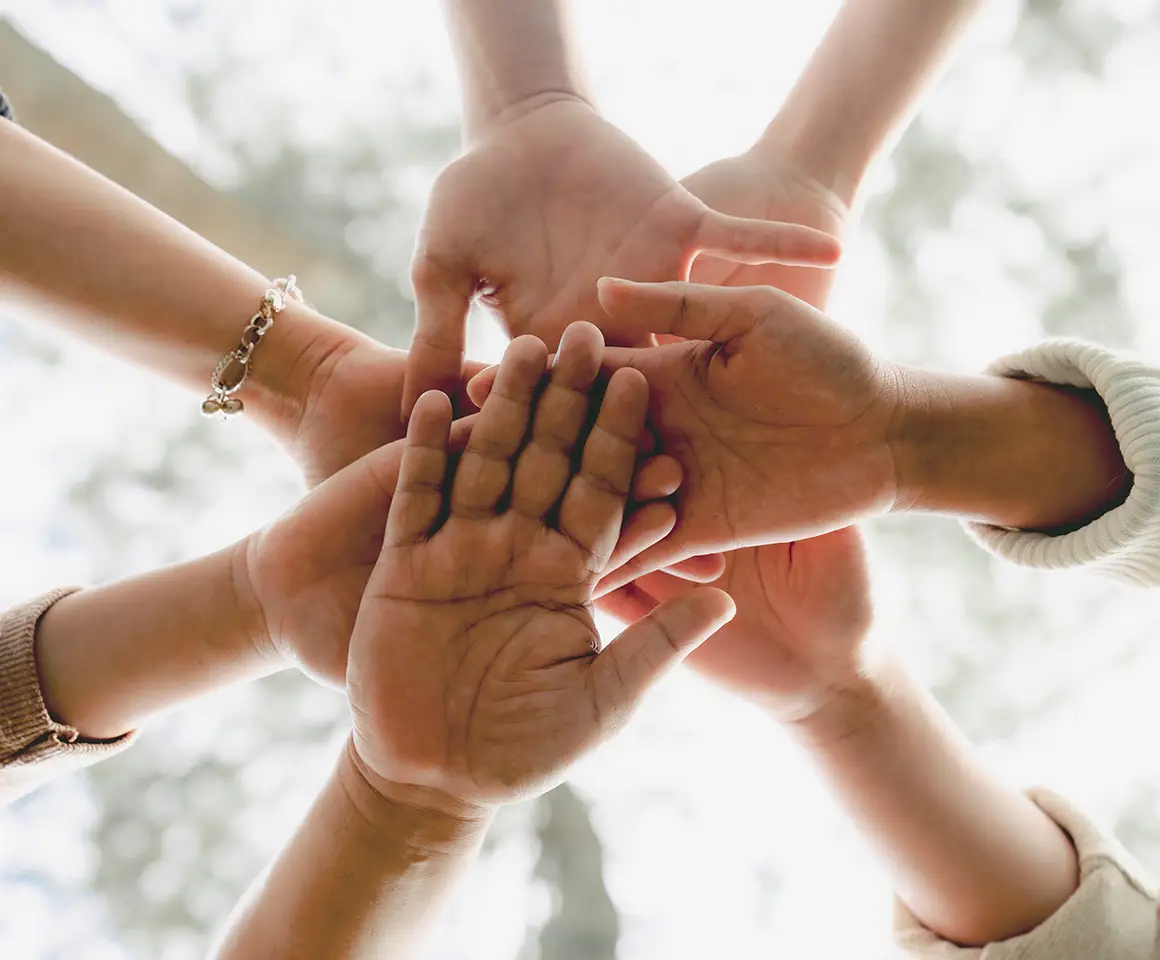 Low Angle View of young multiracial group of people Shaking hands
