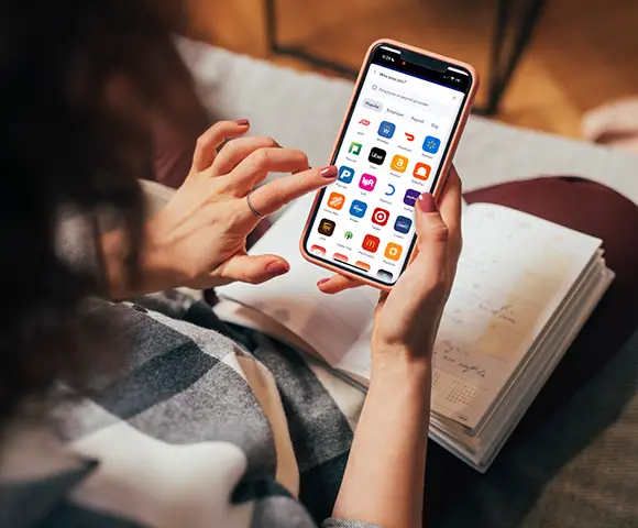 Woman using her mobile phone to access her apps at home