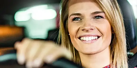 smiling woman driving her car