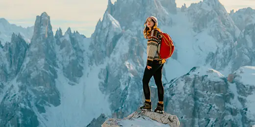 young female hiker overlooking from top of the mountain