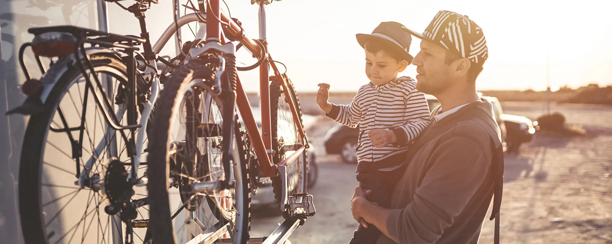 father and son ready to ride bicycles on the beach